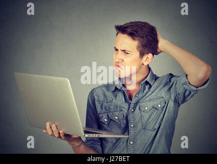 Lustige ratlos dumme Kerl Probleme mit seinem Laptop. Komplizierte Technik-Konzept Stockfoto