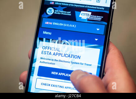 Ein Mann, der Zugriff auf das US-Department für Homeland Security offizielle Esta Visa Waiver Anwendung Website auf seinem Handy. Die Regelung erfordert internationale Reisende sind nicht visumpflichtig beantragen eine Esta steht für Electronic System für Travel Authorisation, und eine geringe Gebühr - um Â £10 - vor der Einreise in das Hoheitsgebiet. Stockfoto