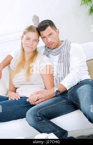 Paar saß auf der Couch, Hand in Hand Stockfoto