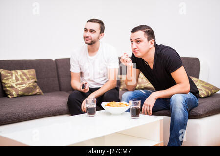 Freunde, Fußball im TV mit Getränken und Snacks zu genießen Stockfoto