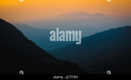 Nepal, März 2017: Schichten der dunstigen Berge in der Ferne bei Sonnenaufgang verblassen. Ulleri nach unten das Tal in Richtung Birethanti entnommen. Annapur Stockfoto