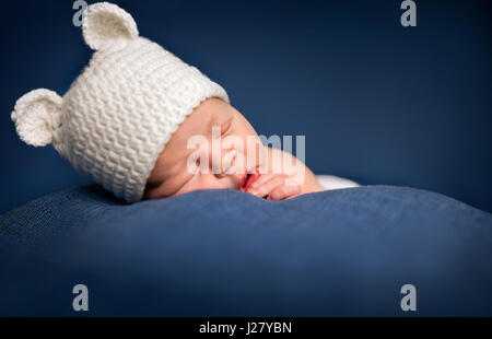 Drei Wochen alten neugeborenes Baby-junge trägt einen braunen gehäkelte Bär Hut und schlafen Stockfoto