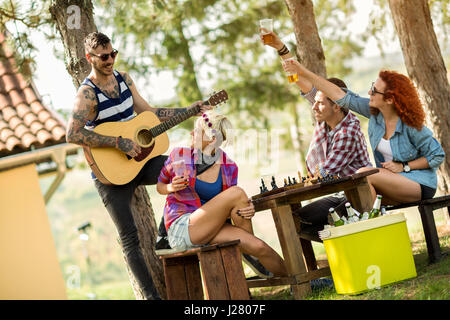 Musik, Gitarre und kühles Bier macht gute Stimmung und junge Menschen glücklich Stockfoto