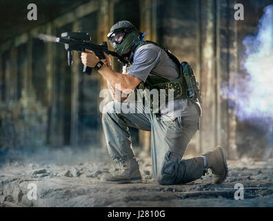 Paintball-Spieler in Aktion mit Paintball-Gewehr Stockfoto