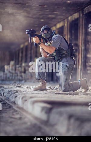 Junger Mann Paintball spielen Stockfoto