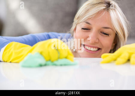 Nahaufnahme der würdige Hausfrau reinigt Tabelle in Wohnung Stockfoto