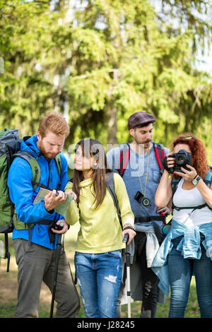 Zwei Mädchen und zwei jungen hielten in Holz zu fotografieren und Pfad auf Karte anzeigen Stockfoto