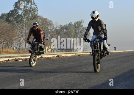 Zwei stunt Motorradfahrer Stoppie nahe Pune, Maharashtra Stockfoto