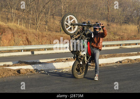 Motorrad Stuntfahrer erklingt in eine Straße in der Nähe von Pune, Maharashtra Stockfoto