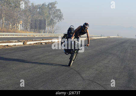 Motorrad Stuntfahrer, Stoppie auf eine Straße in der Nähe von Pune, Maharashtra Stockfoto