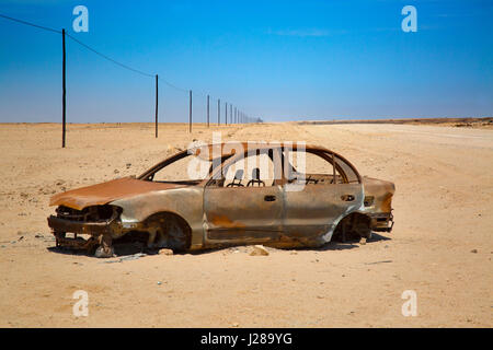 Endlose Schotterstraße C35 und Autowrack Namibia Wüstenregion Stockfoto