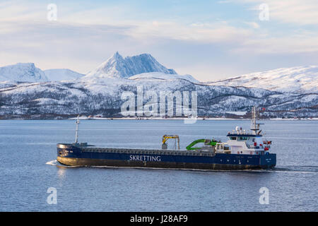 Ein Frachtschiff übergibt einen markanten Berg auf der Insel Senja, Troms Grafschaft, Nord-Norwegen, von Hurtigruten Schiff gesehen. Stockfoto