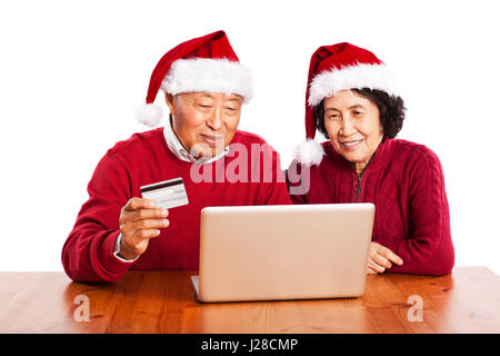 Ein Schuss von senior asiatischen paar Einkaufen online-Weihnachten zu feiern Stockfoto