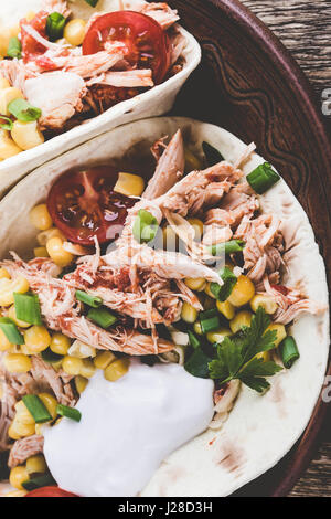 Hausgemachte langsame Herd Chicken Taco mit Mais auf rustikale Keramik-Platte, mexikanischen Stil serviert Stockfoto