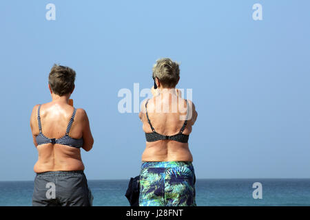 Touristen sehen Surfer am Strand Stockfoto