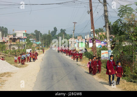 Nepal, Western Region, Bhanu, Annapurna Circuit - Fahrt Kathmandu nach Bhulbhule - Schulkinder in rote Schuluniform auf dem Weg nach Hause Stockfoto