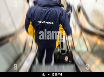 Ryanair-Mitarbeiter am Flughafen terminal Rolltreppe. Flughafen Manchester, England. UK Stockfoto