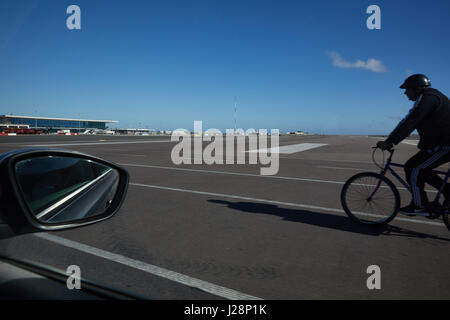 Gibraltar, Flughafen, Autos und Radfahrer überquert die Landebahn, die von der Hauptstraße 'Winston Churchill Avenue' überschritten wird Stockfoto