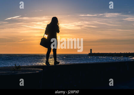 Frau Spaziergänge auf einem Holzsteg in Foz Douro Bezirk von Porto Stadt, zweitgrößte Stadt in Portugal Stockfoto