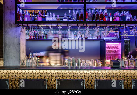 Leuchtende Bar mit einer Betonstütze und ein Rack mit gold Metal Band Muster. Es gibt Regale mit vielen Flaschen und Gläser, Kühlschrank, bar-Ausstattung Stockfoto