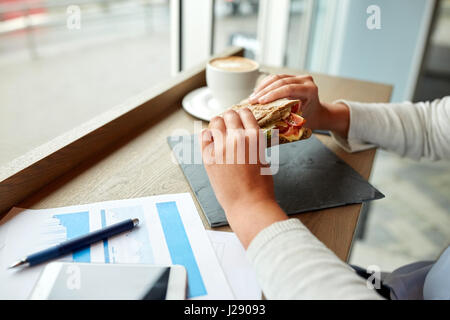 Frau beim Lachs Panini Sandwich in café Stockfoto