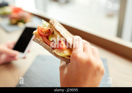 Hand mit Lachs Panini Sandwich Restaurant Stockfoto