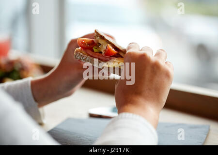 Frau essen Lachs Panini Sandwich Restaurant Stockfoto