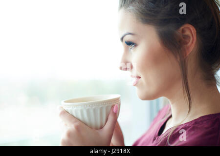 Kopfschuss von attraktiven Frau mit Kaffee am Morgen Stockfoto