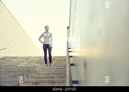 sportliche Frau, die auf in Stadt Treppe Stockfoto