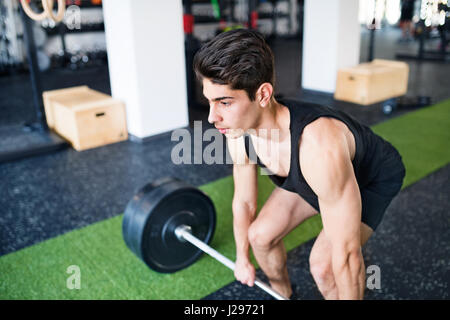 Junge fit hispanic Mann in Turnhalle heben schwere Langhantel, Muskeln Stockfoto