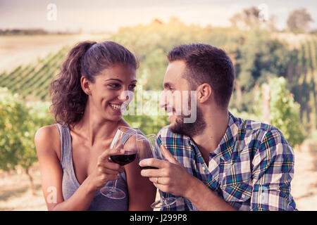 junges Paar Toasten in einem Weinberg Stockfoto