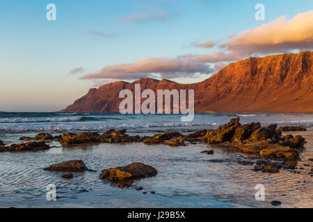 Sonnenuntergang in Caleta de Famara, berühmte surfen Resort auf Lanzarote, Kanarische Inseln, Spanien. Famara Klippen und Strand Stockfoto