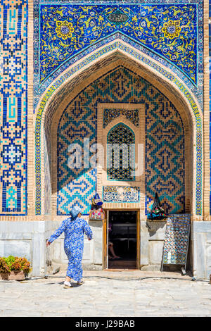 SAMARKAND, Usbekistan - 28 AUGUST: Frau vorbei am Eingang zu den Souvenir-Shop im Atrium des Registan Samarkand, Usbekistan. August 2016 Stockfoto