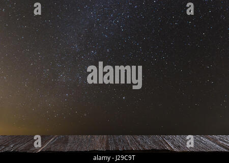 Nacht Himmel mit viele glänzende Sterne, natürliche Astronomie Landschaft mit ausgewählten Schwerpunkt Holz Tisch für Montage oder zeigen Sie Ihr Produkt Stockfoto