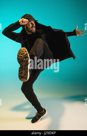Die Silhouette von einem Hip-Hop-männliche Pause Tänzer tanzen auf farbigen Hintergrund Stockfoto