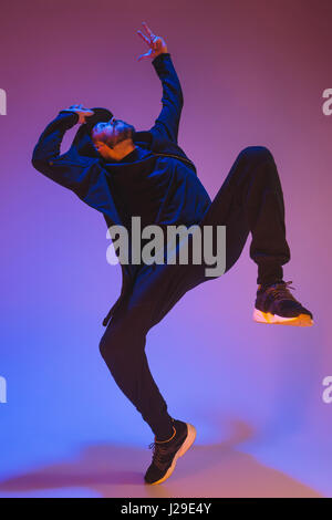 Die Silhouette von einem Hip-Hop-männliche Pause Tänzer tanzen auf farbigen Hintergrund Stockfoto