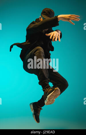 Die Silhouette von einem Hip-Hop-männliche Pause Tänzer tanzen auf farbigen Hintergrund Stockfoto
