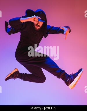 Die Silhouette von einem Hip-Hop-männliche Pause Tänzer tanzen auf farbigen Hintergrund Stockfoto