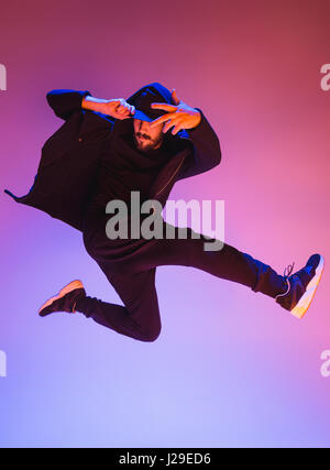 Die Silhouette von einem Hip-Hop-männliche Pause Tänzer tanzen auf farbigen Hintergrund Stockfoto