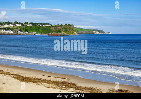 Strand, Felsen, Hafen und atlantischen Küste von Ballycastle im County Antrim, Nordirland, Vereinigtes Königreich, mit dem fernen Blick auf Carrick-a-Rede Stockfoto