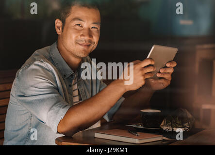 Content-asiatischen Mann, Surfen im Internet, beim Sitzen in einem café Stockfoto