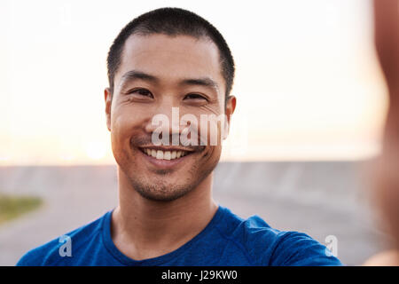 Sportlicher asiatischen Mann unter einem Selfie während eines morgendlichen Lauf Stockfoto