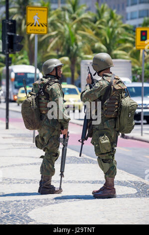 RIO DE JANEIRO - 15. Februar 2017: Zwei Soldaten in voller Tarnung Uniformen stehen mit Gewehren an der Copacabana während eines Polizei-Streiks. Stockfoto