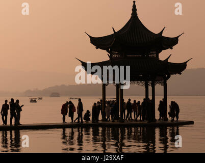 Besuchern stehen in der Silhouette am Westsee Pagode in Hangzhou, China Stockfoto