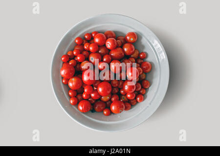 frische reife rote Cherry Tomaten auf einem weißen Teller, Hause angebaut Herbsternte - isoliert auf weißem Hintergrund - Clipping-Pfad Stockfoto