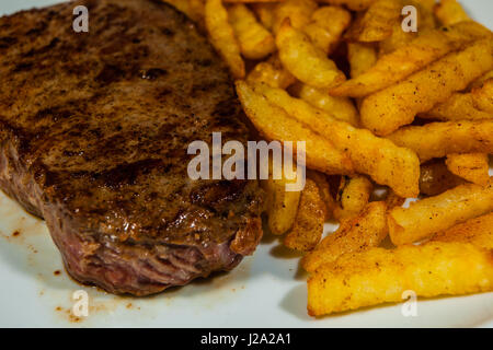 Ein saftige und leckere Steak mit Pommes frites ist ein schnelles und leckeres Essen Stockfoto