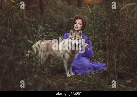Mädchen mit Husky Hund, sind sie in den dunklen Wäldern, wie ein Märchen. Stockfoto