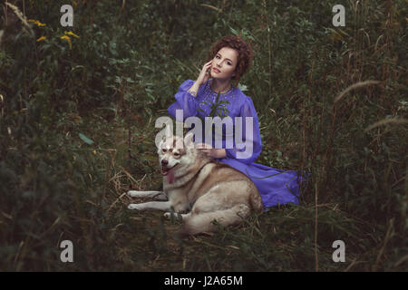 Der Wald Fee Sitzendes Mädchen mit dem Hund Laika. Stockfoto
