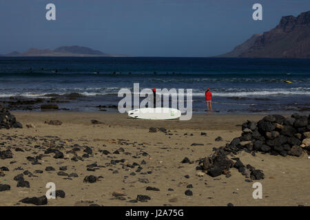 Surfer warten auf die perfekte Welle am Famara, Lanzarote. Stockfoto