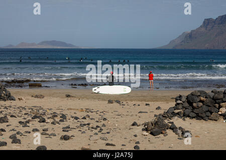 Surfer warten auf die perfekte Welle am Famara, Lanzarote. Stockfoto